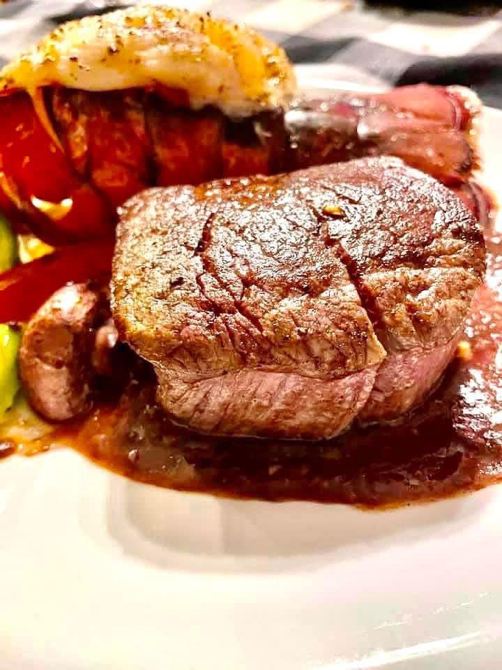 Plated steak with sauce on a white plate