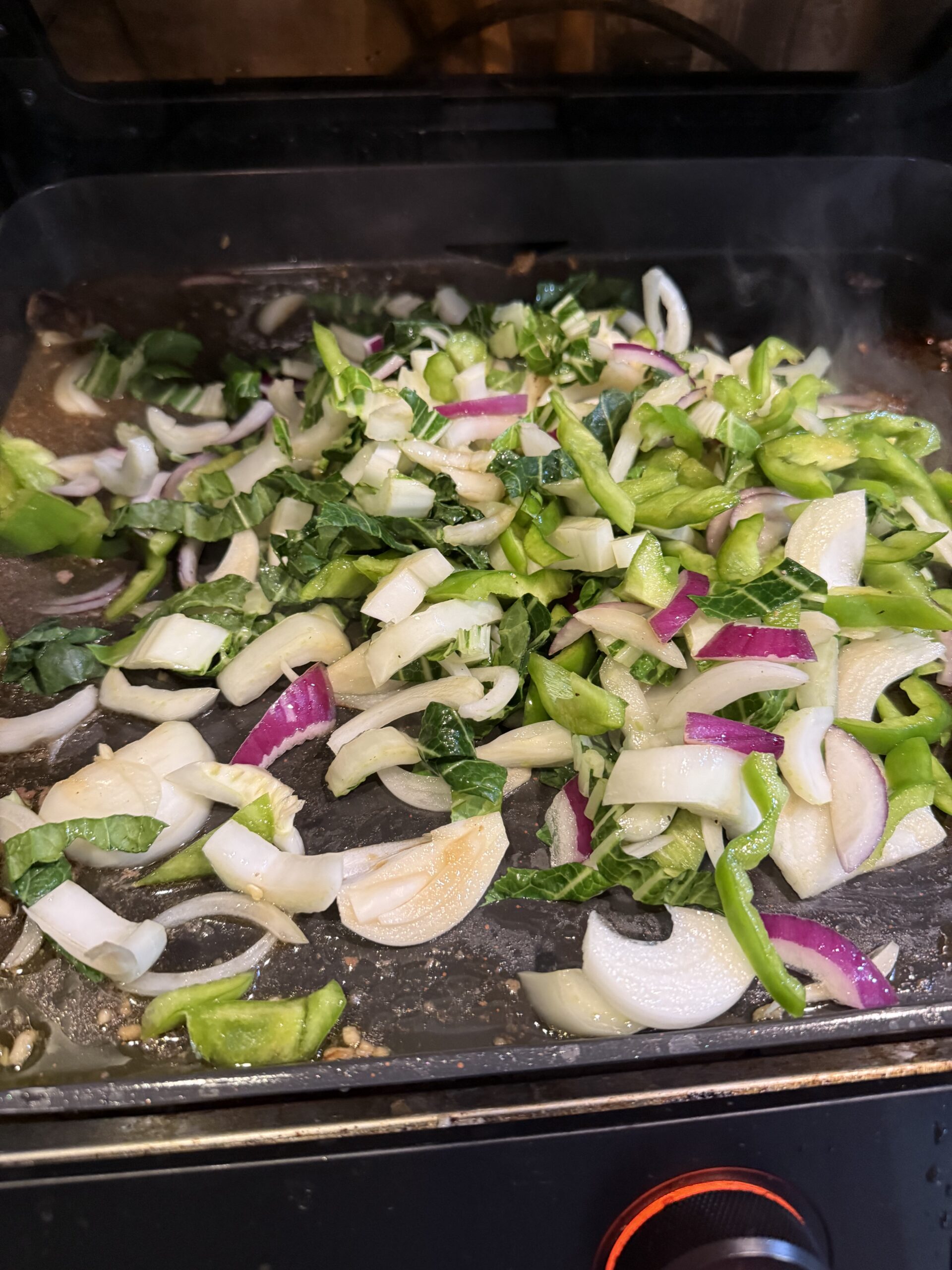 Chopped hibachi vegetables cooking on a flat-top grill